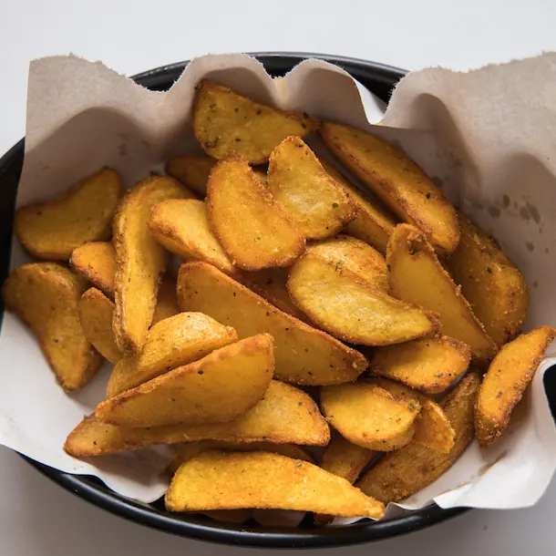 Golden crispy wedges served on a black platter